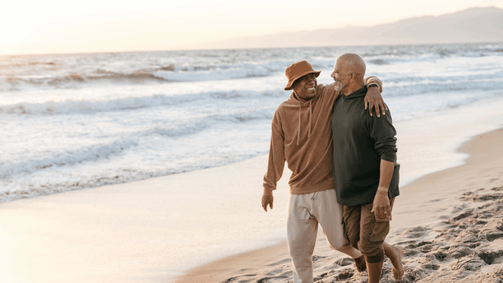 retired gay couple walking on the beach